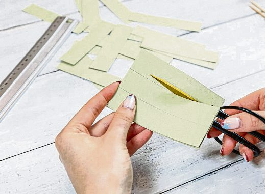 Das Tonpapier längs halbieren und jede Hälfte in 12 etwa 2,5 cm breite Streifen schneiden.