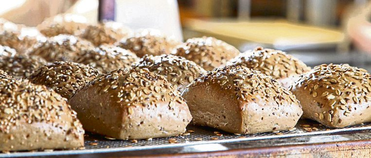 Frisch gebackene Körnerbrötchen warten in der Backstube der Bäckerei Grund auf den Verkauf.