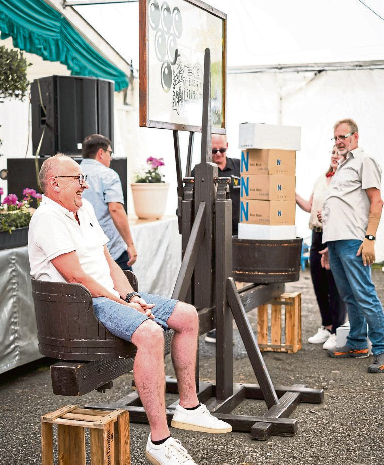 Beim Weinwiegespiel im großen Festzelt wird der Hauptgewinner auf der historischen Holzwaage gewogen - als Preis gibt es Wein entsprechend dem eigenen Körpergewicht. Foto: Marius Franzmann