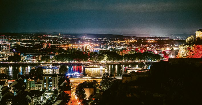 Vom Ehrenbreitsteiner Hang öffnet sich der Blick über den Rhein, die beleuchtete Stadt und die Schiffe. Foto: Koblenz-Touristik/Janko.Media
