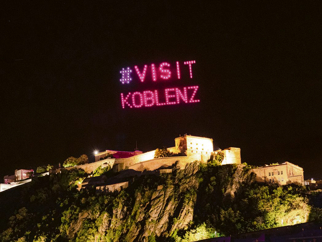 Die Drohnenshow setzt über der angestrahlten Festung Ehrenbreitstein ein weithin sichtbares Zeichen für Koblenz. Foto: Koblenz-Touristik/Johannes Bruchhof