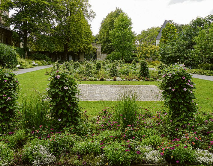 Der Paradiesgarten an der Basilika St. Kastor bietet mit üppiger Bepflanzung und ruhigen Wegen eine grüne Auszeit in der Altstadt. Foto: Verena Groẞ