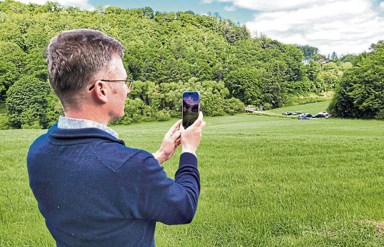 Tobias Panne, Erster Beigeordneter der VG Montabaur, zeigt, wie mittels Augmented Reality das verschwundene Dorf Sespenroth auf dem Smartphone wieder sichtbar wird. Foto: VG Montabaur, Viola Marschall