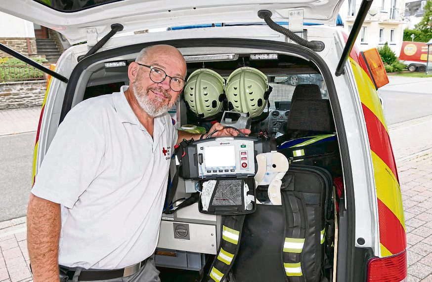 Markus Rosenbach mit einem Defibrillator am vollgepackten First-Responder-Fahrzeug.