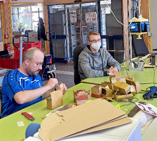  Im Berufsbildungsbereich macht Pierre Tausch sein FSJ. Daniel Hoffmann (links) trainiert das Verpacken von Schrauben.